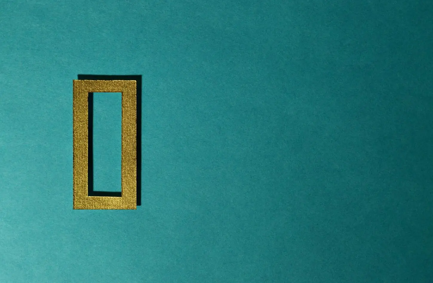 Gold colored "zero" digit on a green-blue background.